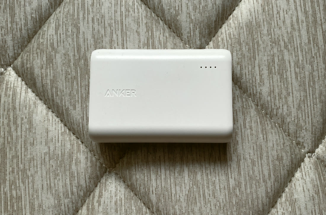 Photo of the author's own white Anker PowerCore 10000 on a quilted blanket